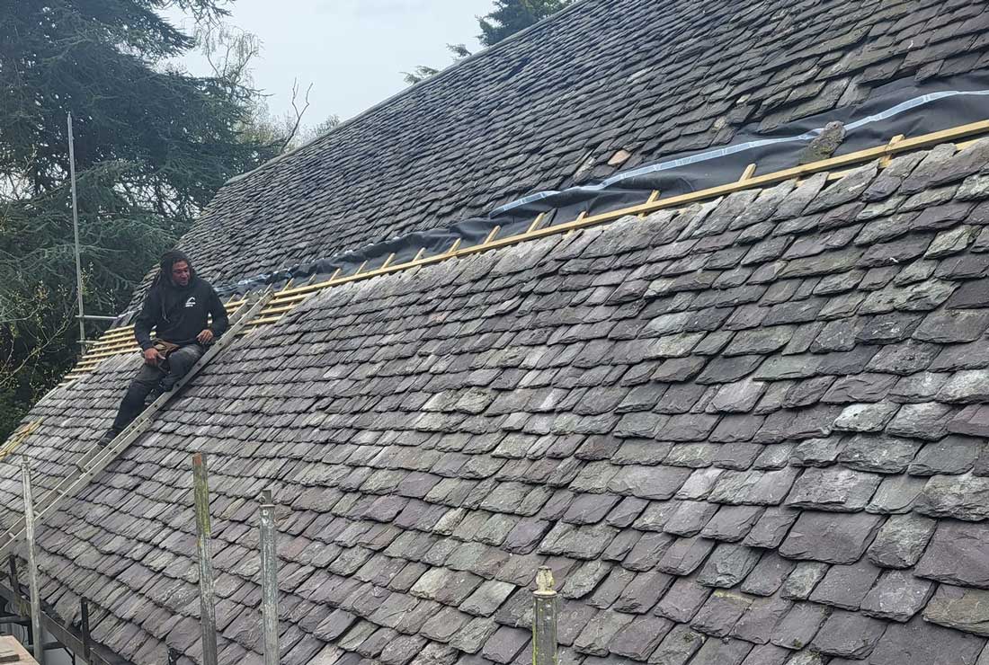 Man fixing old style tile roof